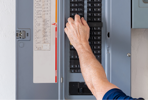 A man checking a tripped circuit breaker in a Simi Valley, CA.